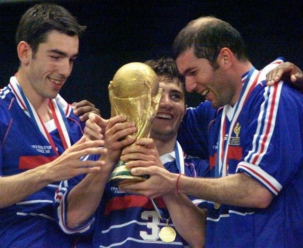 Os franceses Robert Pires (esq.), Bixente Lizarazu e Zinedine Zidane seguram a taça da Copa do Mundo 