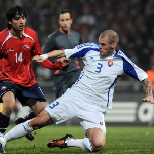 Zagueiro Martin Skrtel tenta desarmar adversrio chileno durante jogo amistoso da Eslovquia