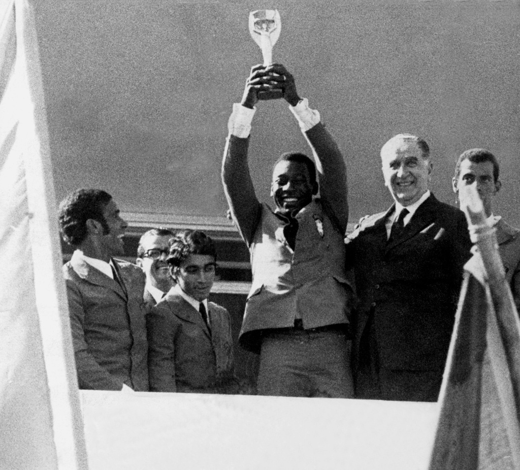 Pelé ergue a taça Jules Rimet ao lado do General Emilio Garrastazu Medici após vencer a Copa do Mundo de 1970