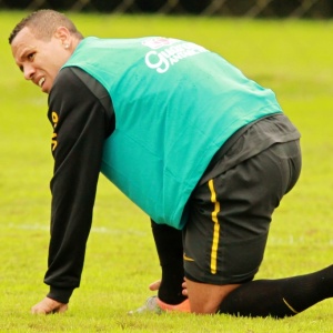 Lus Fabiano faz cara de dor e pe a mo no tornozelo direito durante treino da seleo brasileira