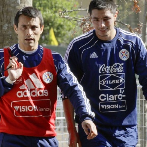 Goleiro Justo Villar e o atacante Oscar Cardozo (d) chegam para treino com portões fechados