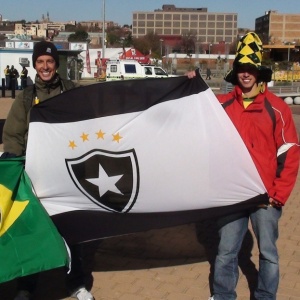 Com a bandeira do Botafogo, torcedores esperam abertura do porto para estreia do Brasil na Copa