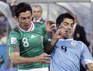 Israel Castro luta pela bola com o uruguaio Luis Surez; volante acredita em vaga nas quartas