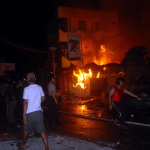 Indonsios tentam apagar fogo em casas aps conflitos ocorridos por causa da Copa do Mundo
