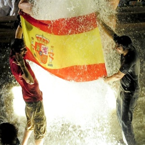 Torcedores comemoram com bandeira espanhola em uma fonte de gua na cidade de Barcelona