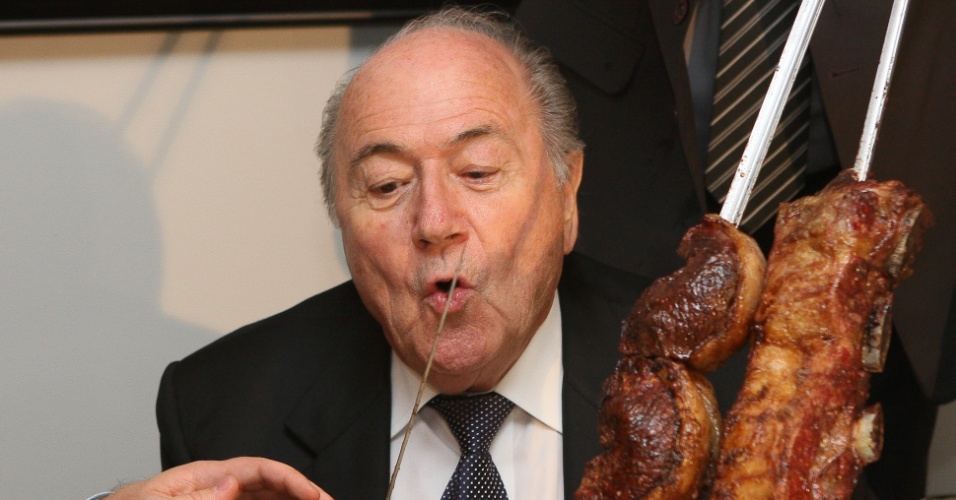 Joseph Blatter, presidente da Fifa, faz careta ao cortar carne oferecida a ele em almoço na casa do presidente da Câmara, o deputado Marco Maia (PT-RS)