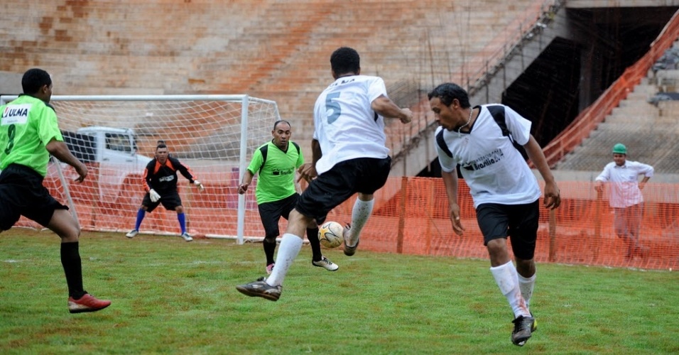 Funcionário tenta lance durante jogo entre os operários do Estádio Mané Garrincha, em Brasília, que está em obras para a Copa de 2014