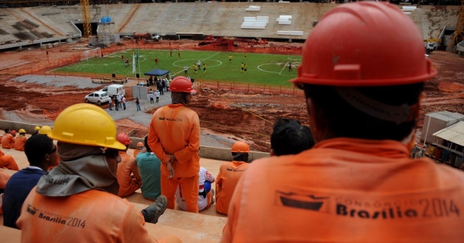 Operários observam partida dos companheiros no Mané Garrincha, em Brasília, em meio às obras para a Copa-2014